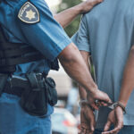 Technician Gets 20 Years for MTN, Vodacom Theft Stop, handcuffs and hands of police man with criminal in city for justice, crime or corruption. Illegal, arrest and law enforcement officer with suspect, thief or gangster for jail, robbery or fail